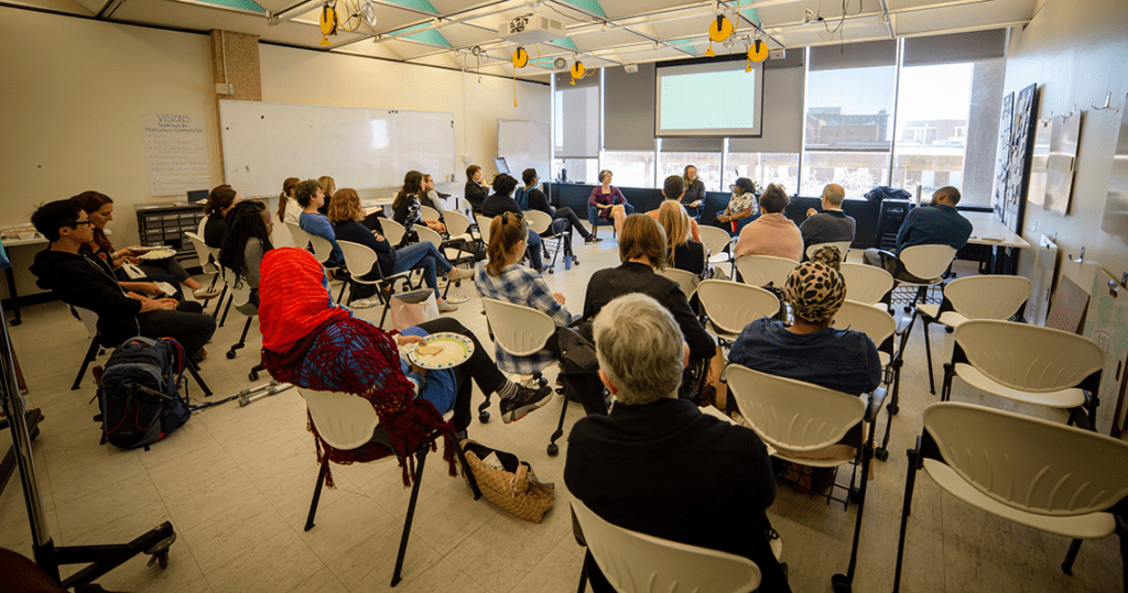 Researchers and scholars sitting in the Taylor center space, attending a Social Innovation panel.