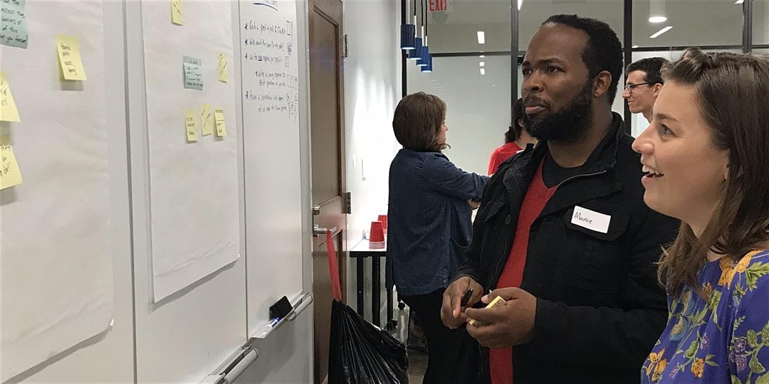 Two people look at a whiteboard during an event at the Taylor Center's Warehouse District Location