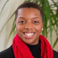 Malliron Hodge smiling wearing a red scarf.