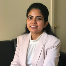 sneha-rout-square Woman smiling wearing a blazer.