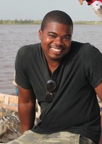 Sedrick-Miles A person smiling for the camera wearing a black shirt in front of a river.