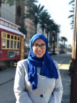 Shaymaa-Abdalal A person wearing a blue head scarf and glasses smiling for the camera